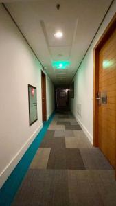 an empty hallway in an office building with a door at Suíte Transamerica Executive Paulista in São Paulo