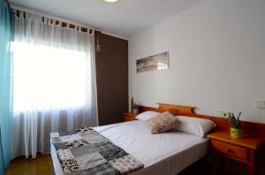 レスカラにあるApartamentos Puig Suredaのベッドルーム(ベッド1台、窓付)