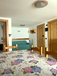 - une chambre avec un lit orné de motifs floraux dans l'établissement Livigno Elisir Petit, à Livigno