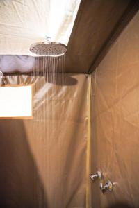 a bathroom with a shower with a shower curtain at Olimba Mara Camp in Mara Simba