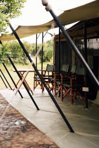 a group of chairs and tables under a tent at Olimba Mara Camp in Mara Simba