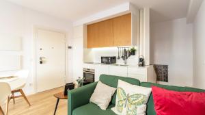 een woonkamer met een groene bank en een keuken bij Old Town 1BR Duplex by LovelyStay in Porto
