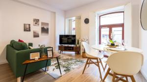 een woonkamer met een groene bank en een tafel bij Old Town 1BR Duplex by LovelyStay in Porto