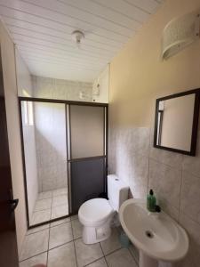 ein Badezimmer mit einem weißen WC und einem Waschbecken in der Unterkunft Suítes Romanetto com Piscina e Vista - Antonina in Antonina
