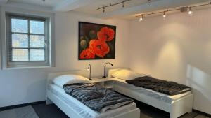twee bedden in een kamer met een schilderij aan de muur bij KLEEBLATT Residenz am Rathaus in Sarstedt