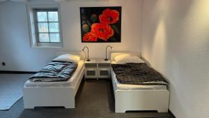 2 bedden in een kamer met een bureau en een raam bij KLEEBLATT Residenz am Rathaus in Sarstedt