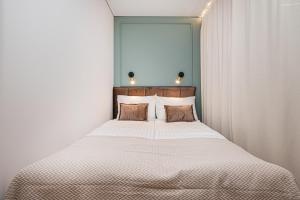 una camera da letto con un grande letto con due cuscini di A&I city view apartment a Vilnius