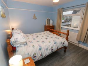 um quarto com uma cama e uma janela em Sŵn Y Môr em Burry Port