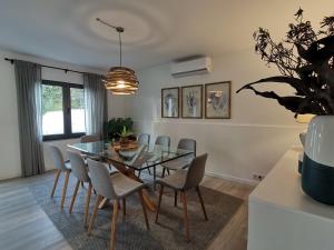 une salle à manger avec une table et des chaises en verre dans l'établissement WelcomeBuddy - Villa Mar Azul - Mosteiros Beach, à Mosteiros