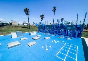 an empty playground with blue and white chairs on it at Nautical Retreat (Unit 5) in Galveston