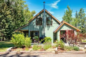 a green house with a gambrel roof at Charming Scandinavian Modern Riverfront Fishhouse in Hailey