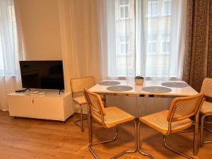 a living room with a table with chairs and a tv at Appartement House Jena in Jena