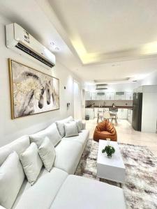 a living room with a white couch and a table at Hittin Luxurious Stay 5 minutes to Boulevard شقة حطين المميزة 5 دقائق للبوليفارد in Riyadh