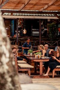 eine Gruppe von Menschen, die an einem Tisch in einem Restaurant sitzen in der Unterkunft Palmar Beach Lodge in Bocas del Toro