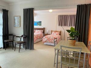 sypialnia z łóżkiem, stołem i krzesłami w obiekcie Sounds Good - Waikawa Holiday Home and Berth w mieście Picton