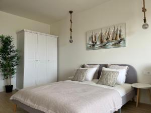 una camera da letto con un letto bianco con vele sul muro di Blue Ocean Morro Jable a Morro del Jable