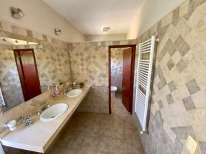 łazienka z 2 umywalkami i toaletą w obiekcie Posada Sausalito w mieście Santa Rosa de Calamuchita