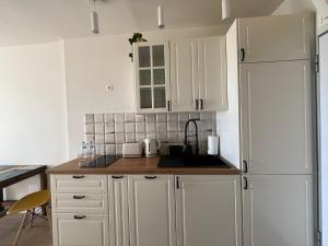 uma cozinha com armários brancos, um lavatório e um frigorífico em Blue Ocean Morro Jable em Morro del Jable
