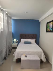 um quarto com uma cama com uma parede azul em CASA MARIA em Pisco