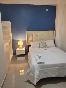 um quarto com uma cama grande e uma parede azul em CASA MARIA em Pisco