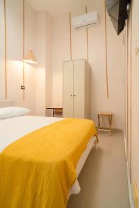 1 dormitorio con manta amarilla en la cama en Hostal Mamamambo, en Santo Domingo