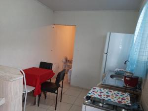 uma cozinha com uma mesa vermelha e um frigorífico em Casa compacta em São Caetano do Sul