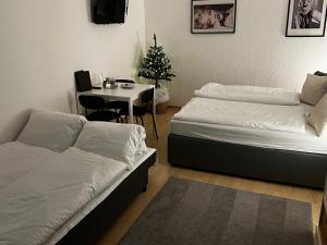 um quarto com duas camas e uma mesa com uma árvore de Natal em Marilyn em Niederwil