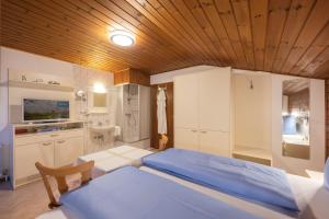 a bedroom with a blue bed and a wooden ceiling at Haus Gerlinde Danler in Neustift im Stubaital