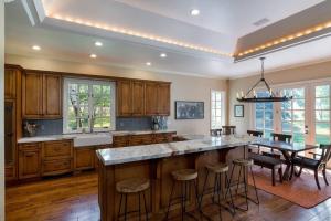 a kitchen with wooden cabinets and a large island with bar stools at Gimlet Family Home Close to Lift with Hot Tub! in Hailey