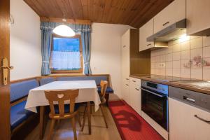a kitchen with a table and chairs in a room at Haus Gerlinde Danler in Neustift im Stubaital