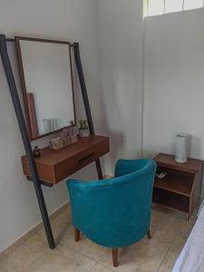 a mirror and a blue chair next to a desk at Maisonette Kavousi with Mountain and Village View in Kavoúsion