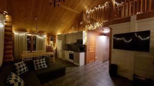 ein Wohnzimmer mit einem Sofa und einer Küche in der Unterkunft Villa Aurora, Himos in Jämsä