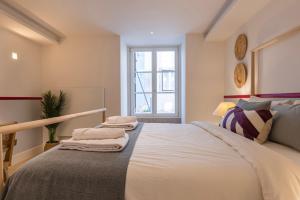 a bedroom with a large bed with towels on it at Palácio Ficalho Townouse 2 by LovelyStay in Lisbon