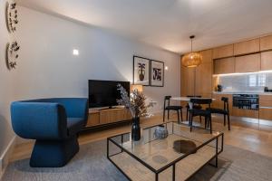 a living room with a blue chair and a table at Palácio Ficalho Townouse 2 by LovelyStay in Lisbon