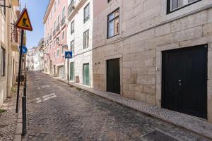 an empty street in an alley with buildings at Palácio Ficalho Townouse 2 by LovelyStay in Lisbon