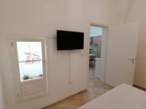 a room with a television on a wall with a window at ELISEA HOUSE MARIO PAGANO in Oria +4 photos