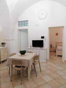 une salle à manger avec une table, des chaises et une horloge dans l'établissement ELISEA HOUSE MARIO PAGANO, à Oria