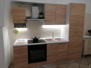 a kitchen with wooden cabinets and a sink at ELISEA HOUSE MARIO PAGANO in Oria