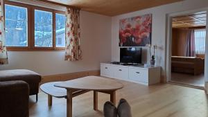 a living room with a table and a tv at Haus Dani Danis in Danis