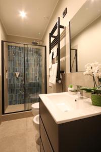 een badkamer met een toilet, een wastafel en een douche bij Meyland suites centro in Milaan