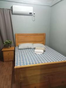 1 dormitorio con 1 cama con aire acondicionado en Travellers&Backpackers Apartment en Calapan