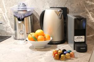a juicer and a bowl of oranges on a counter at Meyland suites centro in Milan