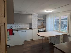 a kitchen with white cabinets and a wooden table at Haus Dani Danis in Danis