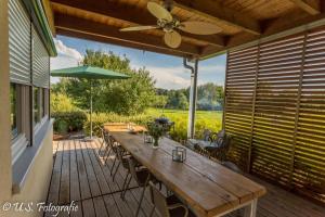 a patio with a wooden table and a ceiling fan at Ferienhaus Beim Viechdoktor in Crailsheim