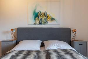 ein Schlafzimmer mit einem Bett mit zwei Nachttischen und einem Gemälde in der Unterkunft Ferienhaus Beim Viechdoktor in Crailsheim