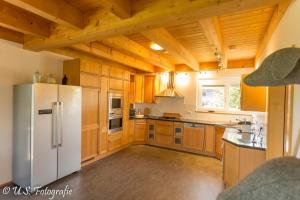 a kitchen with wooden cabinets and a white refrigerator at Ferienhaus Beim Viechdoktor in Crailsheim