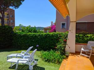 two white chairs sitting on the grass in a yard at Apartamento Playa in S'agaro