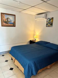 a bedroom with a blue bed in a room at El Callejon Guest House in León