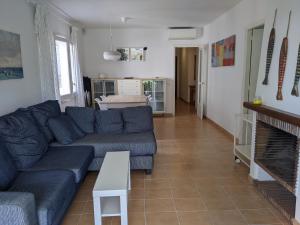 a living room with a blue couch and a fireplace at Apartamento Playa in S'Agaro