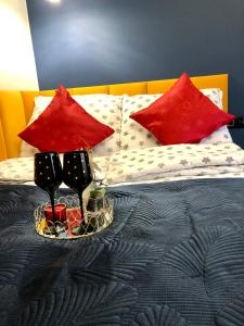 Golden Luxury Suite في نوفي دفور مازوفييتسكي: سرير مع وسادتين حمراء وصينية مع الشموع